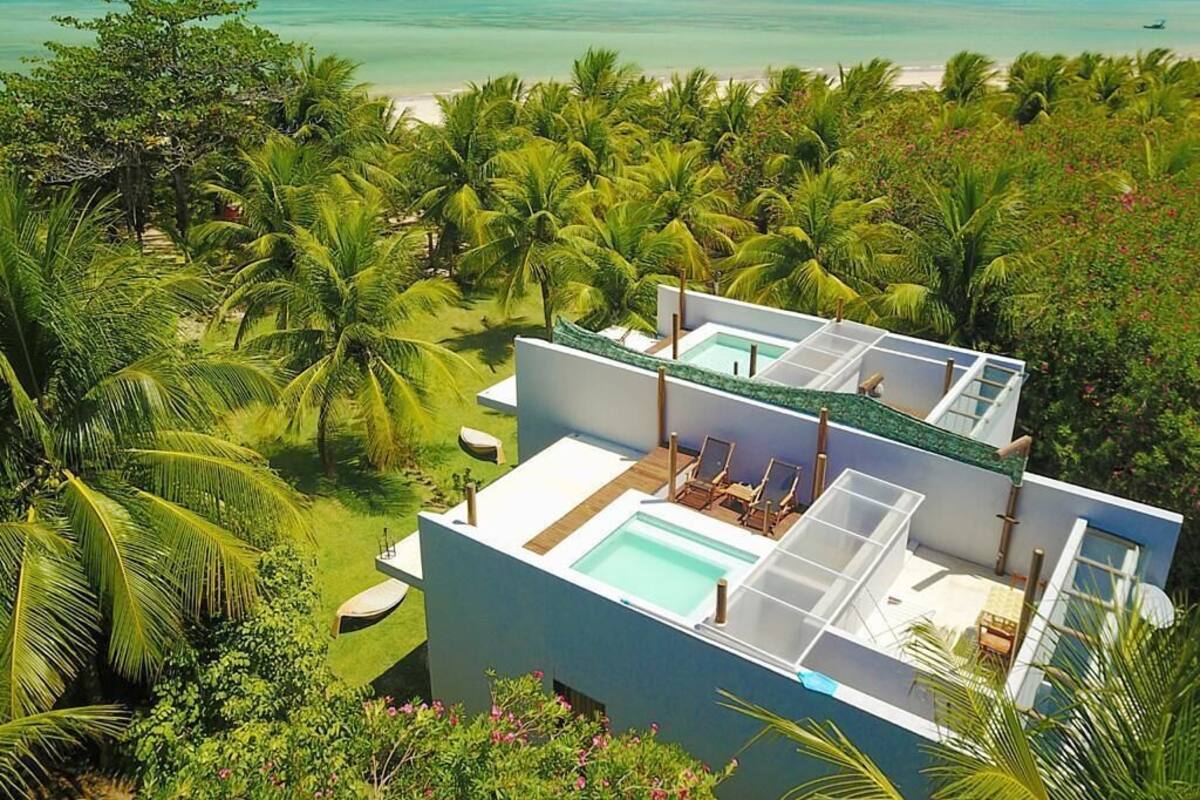 A modern resort with a pool area and a view of the ocean.