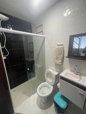 Bathroom features a glass-enclosed shower, white tub, and sink with a mirror above.