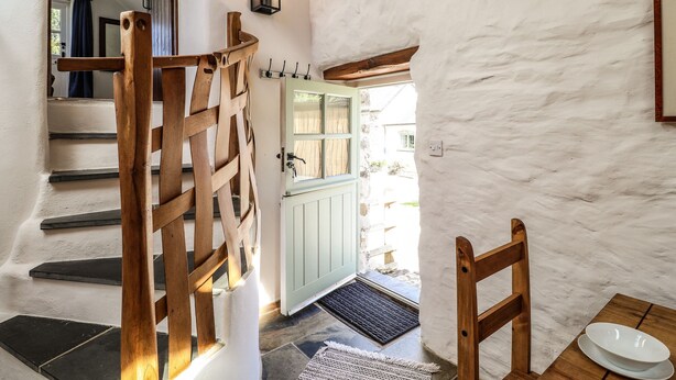A staircase with wooden railings leading to a door with a light green frame. - Y Felin at Coed Cadw (Crymych)