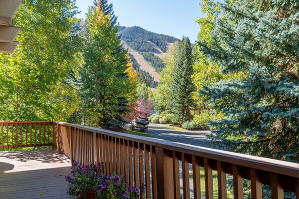 A wooden deck with a view of a forested mountain. - Aspen Home - Pet Friendly, Private Hot Tub & Close to Bald Mountain Ski Lodge (Ketchum)