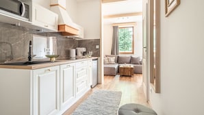 A modern kitchen with white cabinets, a marble countertop, and a built-in microwave. - Apartamenty Villowe - Zakopane Centrum (Zakopane)
