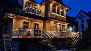 A two-story wooden house with a balcony and a staircase leading to the upper floor. - Apartamenty Villowe - Zakopane Centrum (Zakopane)