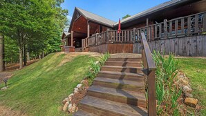 A wooden cabin with a porch and steps leading to a deck. - Breathtaking Views, Seclusion, 4 Bedroom Luxury cabin on 5+ Acres! (Broken Bow)
