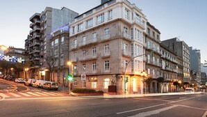 A multi-story building with a classic architectural style, featuring balconies and large windows. - Dorma Vigo (Vigo)