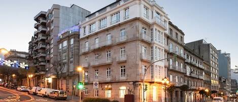 A multi-story building with a classic architectural style, featuring balconies and large windows.