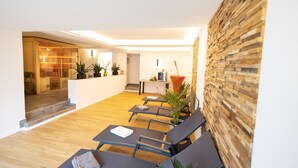 Um hall de hotel moderno com piso de madeira, balcão de recepção e área de estar com poltronas confortáveis.