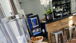 A bar area with a coffee machine, a glass of orange juice, and a basket of pastries. - Hostel Flamingo Nîmes Centre Gare (Nîmes)