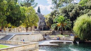 Un parque con una fuente, estructuras de piedra y árboles.