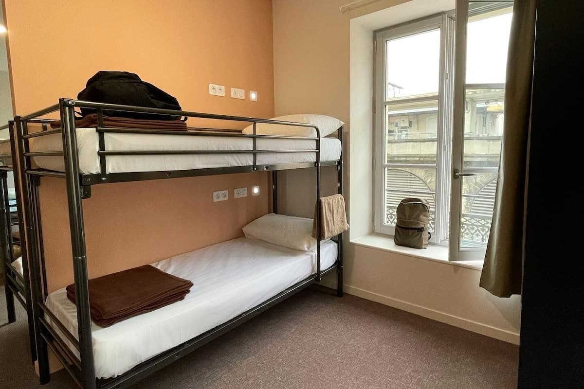 A bunk bed room with a window and a view of the outside.