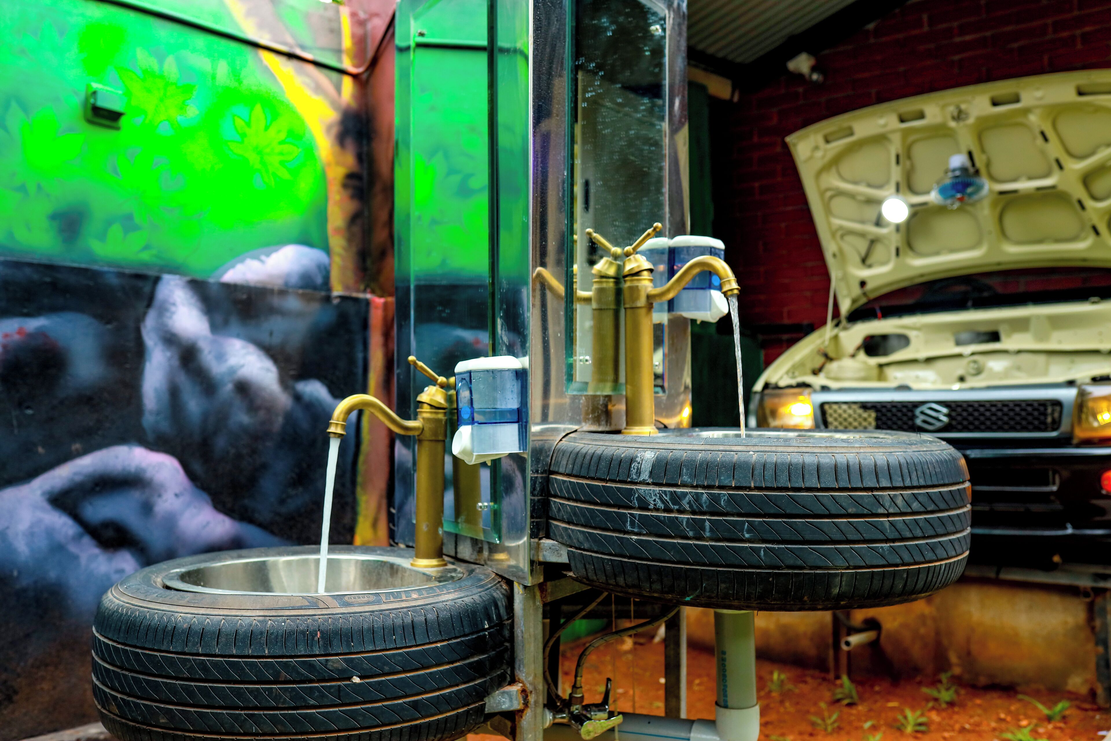A vehicle with a spare tire mounted on a stand, a water pump, and a fuel pump.