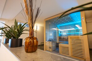 A modern interior with a glass partition, a wooden bench, and potted plants on a counter. - Q-Stall am Poppenberg, Apartment Q4 (Brilon)