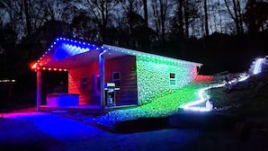 A house with a porch and a garage, surrounded by trees. - Hocking Hills (Buck Crossing Retreat)  (Rockbridge)