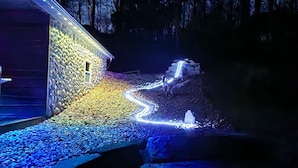 A building with a stone facade and a gravel pathway leading to a wooden deck. - Hocking Hills (Buck Crossing Retreat)  (Rockbridge)