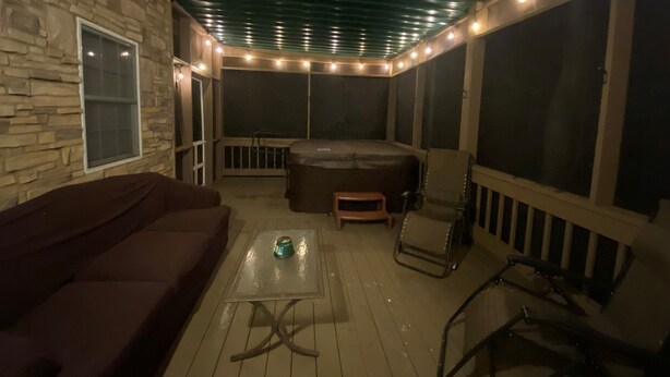 Une terrasse extérieure avec des murs en pierre, un jacuzzi et un espace salon abrité.