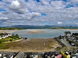 A coastal town with a wide bay, sandy beach, and residential buildings.