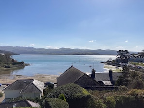 A coastal town with traditional stone buildings, a clear blue sea, and distant hills. - 5 Star Cottage, Sleeps 8, Amazing Sea & Mountain Views, Borth y Gest, Wales (Borth-y-Gest)