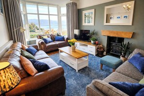 A living room with a sofa set, a coffee table, a television, and a fireplace.