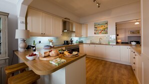 Uma cozinha moderna com bancadas de madeira, uma ilha central e armários brancos.