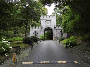 A castle-like structure with a paved pathway leading to an arched entrance. - Clodagh's Cottage (Collooney)