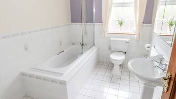 A bathroom with a bathtub, toilet, and sink.