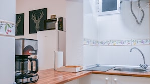 A kitchen with a coffee maker, a microwave, a sink, and decorative wall art. - COZY APARTMENT-LAVAPIES- MADRID CITY CENTER (Madrid)