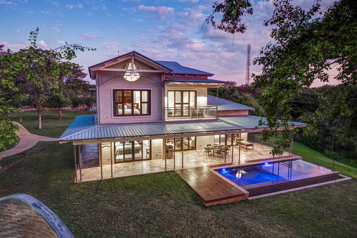 A two-story house with a covered patio and a swimming pool.