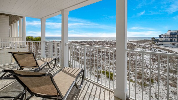 A covered balcony with two lounge chairs, a view of the beach, and a building in the background. - Gulf front home w/6 seater golf cart, priv. pool, direct beach access (Santa Rosa Beach)