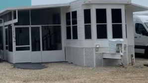 A single-story house with a covered porch and a fenced yard. - Tropical Key Largo RV Getaway with Boat Ramp & Golf Cart (Key Largo)