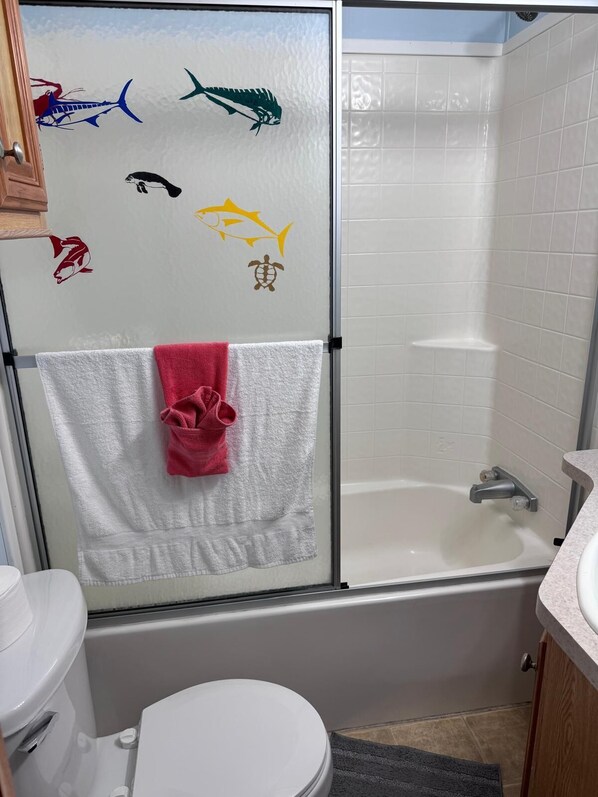 A bathroom with a glass shower enclosure, a white toilet, and a sink with a countertop. - Tropical Key Largo RV Getaway with Boat Ramp & Golf Cart (Key Largo)