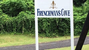 A sign for Frenchmans Cove with a fleur-de-lis logo. - Tha Lagoon Spot (Port Antonio)