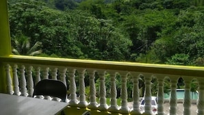 A balcony with a view of a lush green forest and mountains. - Tha Lagoon Spot (Port Antonio)