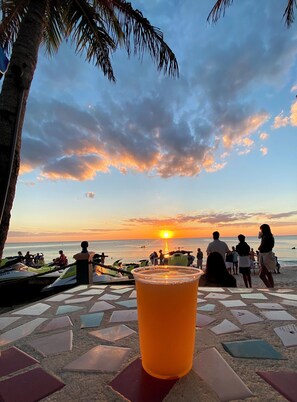 A sunset view with people on a beach and a drink on a tiled table. - Beautiful Marina View (Cape Coral)