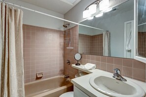 A bathroom with a bathtub, a sink, a mirror, and a towel rack. - Mountainside Retreat - Sleeps 4 (Frisco)