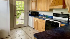 A kitchen with wooden cabinets, a microwave, a dishwasher, a stove, and a sink.