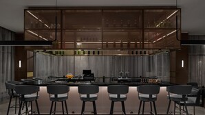 A modern kitchen with a central island, bar stools, and a glass display cabinet above. - AC Hotel Bozeman Downtown (Bozeman)