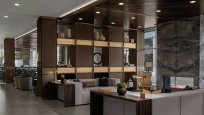 A modern interior with a central seating area, a fireplace, and a large window. - AC Hotel Bozeman Downtown (Bozeman)