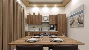 Una cocina moderna con armarios de madera, un salpicadero de mármol y una mesa de comedor para cuatro.
