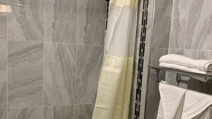 Une salle de bain équipée d’une douche, de toilettes et d’un porte-serviettes avec des serviettes.
