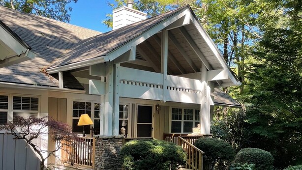 A house with a front porch, stone steps, and a well-maintained garden.