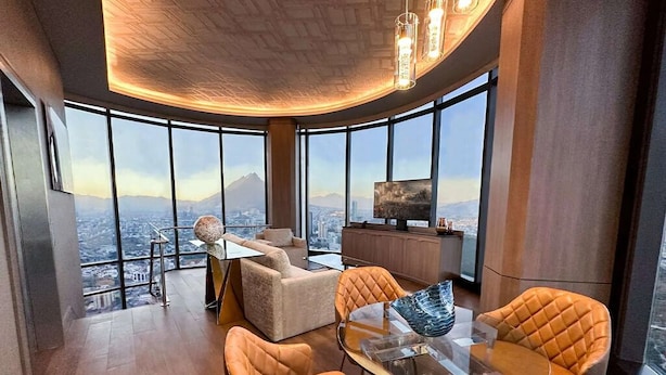 A modern living room with a glass table, leather chairs, a sofa, and a TV. - Safi Royal Luxury Metropolitan (San Pedro Garza García)