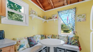 A cozy corner with a bench, a round table, and storage bins.