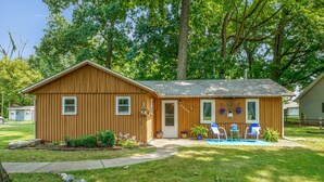 A wooden single-story house with a front porch, a small garden, and a mailbox.