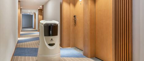 Un pasillo de hotel con una máquina expendedora de café, puertas de madera y alfombra estampada.