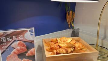 A display of pastries, including croissants and tarts, in a wooden box.