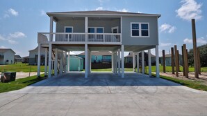 Een tweelaags huis met een balkon, een overdekte patio en een garage.