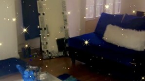 A living room with a blue sofa, a white coffee table, and a blue rug. - Nice Condo for rent in Mid City LA (Los Angeles)