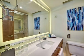 A modern bathroom with a large mirror, a white sink, and a toilet. - Royalton Grenada (St. George's)