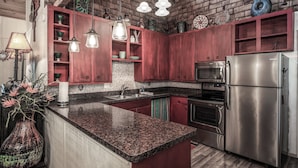 A kitchen with granite countertops, stainless steel appliances, and wooden cabinets. - A Climbing Cub by Ruidoso Vacation Rentals (Ruidoso)