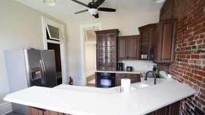 A kitchen with a central island, wooden cabinets, a refrigerator, and a dishwasher. - *Historic Gem* Heart of Southside-Sleeps 10 (Pittsburgh)