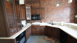 A kitchen with dark wooden cabinets, a microwave, and a sink. - *Historic Gem* Heart of Southside-Sleeps 10 (Pittsburgh)